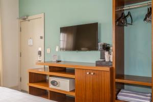 a room with a desk with a tv and a microwave at Kasa El Paseo Miami Beach in Miami Beach