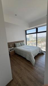 #1 in Andares Pool-Jacuzzi-We invoice free of charge في غواذالاخارا: غرفة نوم بسرير كبير ونافذة كبيرة