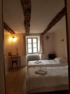 Un dormitorio con dos camas y una ventana. en La maison d'Angèle, en Sainte-Eulalie-du-Cernon