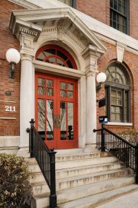 een rode deur op een bakstenen gebouw met een trap bij Kasa Capitol Hill Downtown Nashville in Nashville