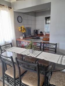 a dining room with a table and chairs and a kitchen at Casa de la Ribera Collipulli in Valdivia