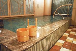 a pool of water with two orange buckets in it at Onyado Nono Namba Natural Hot Spring in Osaka