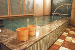 a bath tub sitting next to a pool of water at Onyado Nono Namba Natural Hot Spring in Osaka