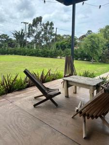 un patio con due sedie, una panchina e un ombrellone di elcontainerdeacantilados a Mar del Plata