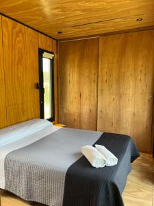 una camera da letto con un letto con due cuscini sopra di elcontainerdeacantilados a Mar del Plata