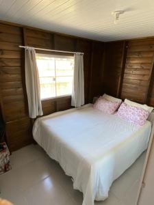 una cama en una habitación con ventana en Casa com Piscina em Itapirubá, en Imbituba 18 fotos más