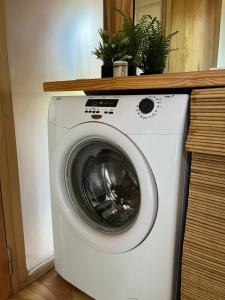 una lavatrice bianca con delle piante sopra di elcontainerdeacantilados a Mar del Plata