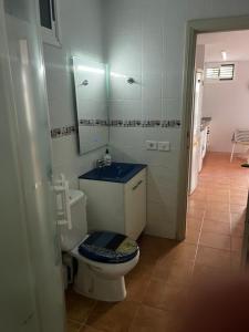 a bathroom with a toilet with a sink and a mirror at Oasis de paz junto al mar in Maspalomas +16 photos