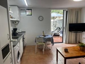 a kitchen with a table and a dining room with a patio at Oasis de paz junto al mar in Maspalomas