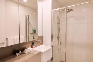Un baño blanco con ducha y lavabo. en 1Br City View apt near SthnCrs Wifi Pool Gym, en Melbourne