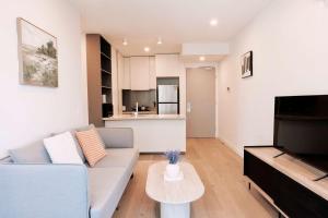 una sala de estar con un sofá y una mesa en 1Br City View apt near SthnCrs Wifi Pool Gym, en Melbourne