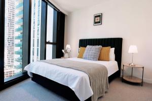 Un dormitorio con una cama grande y una ventana grande. en 1Br City View apt near SthnCrs Wifi Pool Gym, en Melbourne
