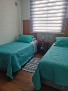 En eller flere senge i et værelse på Arriendo La Serena