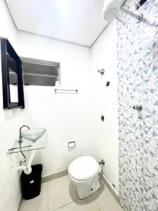 a bathroom with a toilet and a shower at Mar Doce Lar Kitinete in São Vicente