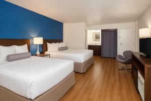 斯波坎Spokane Boutique Hotel的一间配有两张床和一台平板电视的酒店房间