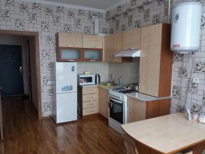 a kitchen with a white refrigerator and a table at Bestshome Apartments in Bishkek