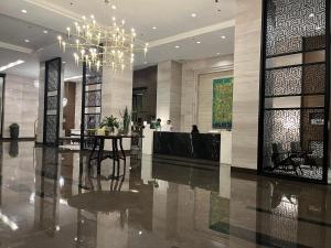 Un vestíbulo con una lámpara de araña y una mesa. en Bayfront Suite near Airport, MOA, PICC, Star City, OKADA With Fast WIFI & Netflix Free Pool Access, en Sampong 20 fotos más