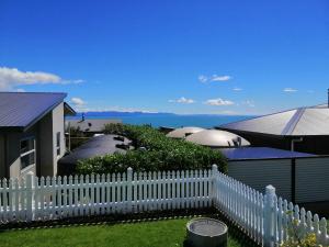 a white picket fence in front of a house at Time Out in Pohara in Pohara