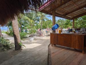 a wooden counter with people sitting at a beach at Banana Beach Club in Moalboal
