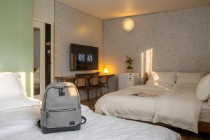 a hotel room with two beds and a suitcase on the bed at Still apartment in Guangzhou