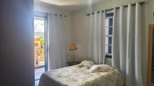 Excelente Apartamento em Casarão Histórico في ماريانا: غرفة نوم بسرير مقابل نافذة