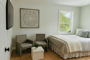 una camera da letto con un letto, due sedie e una finestra di Blue Ridge Main St Mountain View Cottage a Sparta