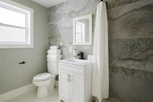 un bagno con un water, un lavandino e uno specchio di Blue Ridge Main St Mountain View Cottage a Sparta Altre 20 foto