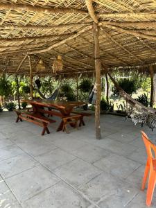 een picknicktafel onder een grote parasol van stro. bij Chácara do sossego in Viçosa do Ceará