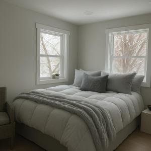 una camera da letto con un letto grande con due finestre di Blue Ridge Main St Mountain View Cottage a Sparta