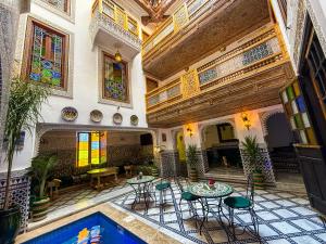 an indoor courtyard with tables and chairs in a building at Riad Dar El bellar in Fès