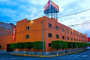 ein rotes Backsteingebäude mit einem neonbeleuchteten Motelschild in der Unterkunft Hotel Puente in Mexiko-Stadt