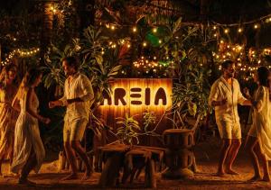 a group of people standing around a sign with lights at Mayan Monkey Isla Mujeres - Social Hotel in Isla Mujeres