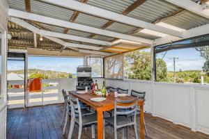 a dining room with a table and chairs on a balcony at Love You Moore in Guilderton