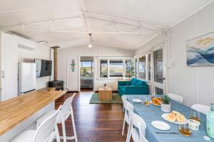 a kitchen and living room with a table and chairs at Love You Moore in Guilderton