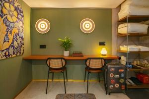a room with two chairs and a desk with a suitcase at Still apartment in Guangzhou