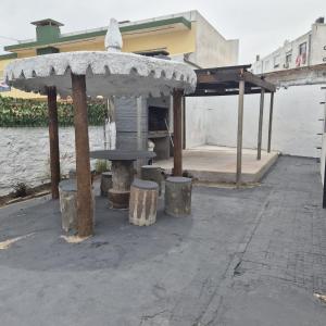 Un refugio para picnic con mesa y taburetes. en Casa en el centro de Piriapolis a 1 cuadra de la playa, en Piriápolis