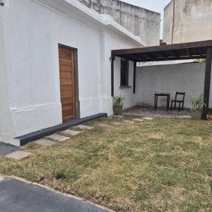 un edificio blanco con puerta de madera y patio en Casa en el centro de Piriapolis a 1 cuadra de la playa, en Piriápolis