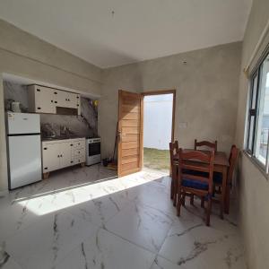 una cocina vacía con mesa y ventana en Casa en el centro de Piriapolis a 1 cuadra de la playa, en Piriápolis