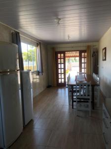 A melhor Casa na praia para temporada في باليوسا: مطبخ وغرفة طعام مع طاولة وثلاجة +9 صور