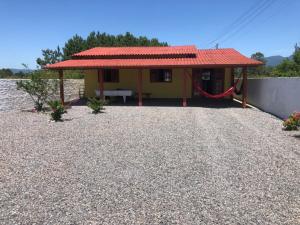 A melhor Casa na praia para temporada في باليوسا: منزل اصفر صغير بسقف احمر