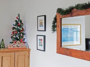 Ein Weihnachtsbaum auf einer Kommode neben einem Spiegel in der Unterkunft Baytree Cottage in Fareham