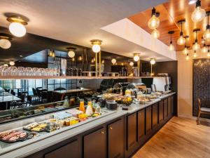 ein Buffet mit viel Essen in der Unterkunft Mercure Paris Montparnasse Pasteur in Paris