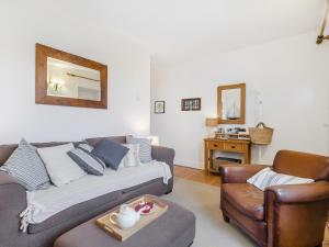 ein Wohnzimmer mit einer Couch und einem Sessel in der Unterkunft Baytree Cottage in Fareham