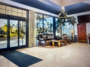 a living room with a couch and large windows at SURESTAY BY BESTWESTERN BAKERSFIELD CENTRAl in Bakersfield