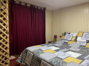 Un dormitorio con una cama con una colcha encima en Clocabana, en Totoralillo