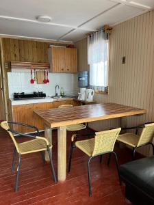 Una cocina con una gran mesa y sillas de madera. en Clocabana, en Totoralillo