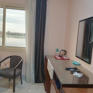 Un escritorio y una silla en una habitación con ventana. en Nile jewel hotel beni suef, en Beni Suef