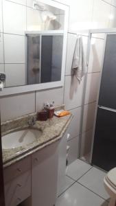 a bathroom with a sink and a mirror and a toilet at Chácara mobiliada próximo Criciúma Br101 in Araranguá +15 photos