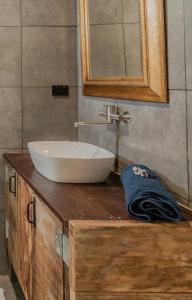 Bridge Moore Lodge في Bucca: حمام مع حوض أبيض ومرآة