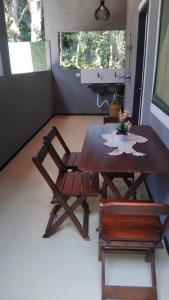 a dining room with a table and a chair at Vila mar azul in Imbassai